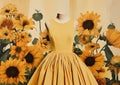 Minimalistic collage of yellow autumn dress and sunflowers around on yellow background. Surreal collage-style paintings