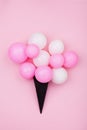 Minimalistic composition for birthday with balloons ice cream in waffle cone on pink pastel background top view. Flat lay style.