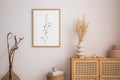 Minimalistic composition of living room interior with mock up poster frame, beige vase with dried flowers, wooden round coffee Royalty Free Stock Photo