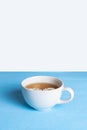 A minimalistic composition of one white cup of chamomile tea on a white-blue background. Place for text Royalty Free Stock Photo