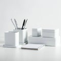 A minimalistic desk setup features several white, rectangular storage containers,