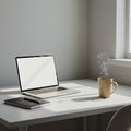 Minimalistic desk setup with a laptop, closed notebook, and pen on a white surface.