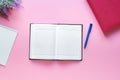 minimalistic desktop - diary, pen, notebook for notes, flat lay on a pink background