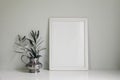 Minimalistic elegant living room interior with white wooden picture photo frame on table. Olive twig in vintage silver Royalty Free Stock Photo