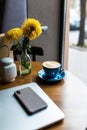 Minimalistic flat lay composition. Laptop computer, cell phone gadget, cup of coffee on textured wooden desk table background.