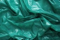 Minimalistic green texture of transparent wrinkled plastic. Crumpled wrinkled plastic cellophane. Reflects light and shadow on the