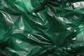 Minimalistic green texture of transparent wrinkled plastic. Crumpled wrinkled plastic cellophane. Reflects light and shadow on the