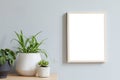 Minimalistic home interior with mock up photo frame on the brown table with composition of cacti and succulents. Royalty Free Stock Photo