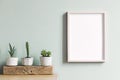 Minimalistic home interior with mock up photo frame on the brown table with composition of cacti and succulents. Royalty Free Stock Photo