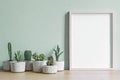 Minimalistic home interior with mock up photo frame on the brown table with composition of cacti and succulents. Royalty Free Stock Photo