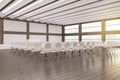 Minimalistic loft style concrete and wooden auditorium with window and city view, stage and many chairs.