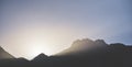 Minimalistic mountain landscape, the sun\'s rays shine from behind the mountain, a dark mountain at sunset in the evening Royalty Free Stock Photo