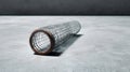 Minimalistic photo of wire mesh roll on gray concrete floor Royalty Free Stock Photo