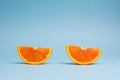 Minimalistic pop art color concept: two slices of orange fruit on blue background