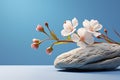 Minimalistic scene stone with flowers on a light blue background
