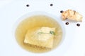 Minimalistic serving of food, white transparent chicken broth in a plate of rice, cheese and dumplings Royalty Free Stock Photo