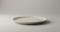 A minimalistic setting featuring a plain, round ceramic plate with a smooth matte finis Royalty Free Stock Photo