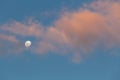Minimalistic skyscape - moon, sky and clouds glowing in orange sunset light. Royalty Free Stock Photo