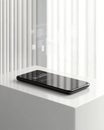 Minimalistic smartphone on a white surface showcasing futuristic data visualization and digital holographic graphics