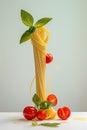 A minimalistic still life concept: A neatly arranged stack of spaghetti adorned with fresh tomatoes and basil on grey