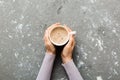 Minimalistic style woman hand holding a cup of coffee on Colored background. Flat lay, top view cappuccino cup. Empty