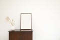 Minimalistic and stylish mock up poster frame standing on cabinet, concept with retro furnitures,brown cabinet,White Royalty Free Stock Photo