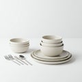 A minimalistic tableware set featuring stacked beige ceramic bowls and plates. The Royalty Free Stock Photo