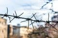 Minimalistic urban barbed wire against blurred cityscape background Royalty Free Stock Photo
