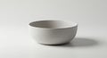 A minimalistic, white ceramic bowl with a smooth texture on a plain, light gray Royalty Free Stock Photo