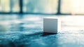 Minimalistic white cube on a textured surface with soft light