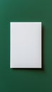 Minimalistic white rectangular paper on a green background, creating a stark contrast between the two surfaces with simplicity. Royalty Free Stock Photo