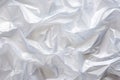 Minimalistic white texture of transparent wrinkled plastic. Crumpled wrinkled plastic cellophane. Reflects light and shadow on the