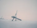 Minimalistic winter background with a frozen wooden chair with a frosty haze against the pink sky of the polar day