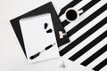 Minimalistic workspace book, notebook, pencil, cup of coffee, earphones on striped black and white background. Flat layTop view