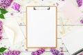 Minimalistic workspace with clipboard, envelope, lilac and accessories on white background. Freelancer or blogger concept. Flat la