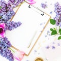 Minimalistic workspace with clipboard, envelope, pen, lilac, petels and accessories on white background. Flat lay, top view. Beaut Royalty Free Stock Photo