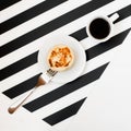 Minimalistic workspace with cup of coffee, bakery, isolated on striped black and white background. Flat lay style Top view. Royalty Free Stock Photo