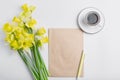 Minimalistic workspace. white work desk with coffee mug, kraft-paper, pen and bouquet flower. top view, flat lay Royalty Free Stock Photo