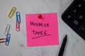 Minimize Taxes text on sticky notes isolated on office desk