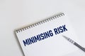 MINIMIZING RISK text on notepad, working paper. Business and financial concept