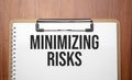 minimizing risks text on white paper on the wood table