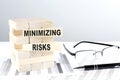 MINIMIZING RISKS is written on wooden blocks on a chart background