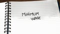 Minimum wage handwriting  text on paper, on office agenda. Copy space Royalty Free Stock Photo