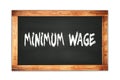 MINIMUM  WAGE text written on wooden frame school blackboard Royalty Free Stock Photo