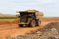 A mining dump truck drives and unloads bauxite minerals