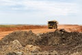 A mining dump truck drives and unloads bauxite minerals