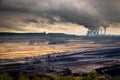 Mining equipment in a brown coal open-pit mine and a power plant with emission Royalty Free Stock Photo