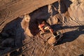 Mining excavator load the sand into dump truck in open pit. Developing the sand in the opencast. Heavy machinery on earthworks in Royalty Free Stock Photo