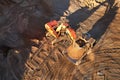 Mining excavator load the sand into dump truck in open pit. Developing the sand in the opencast. Heavy machinery on earthworks in Royalty Free Stock Photo