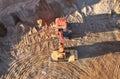 Mining excavator load the sand into dump truck in open pit. Developing the sand in the opencast. Heavy machinery on earthworks in Royalty Free Stock Photo